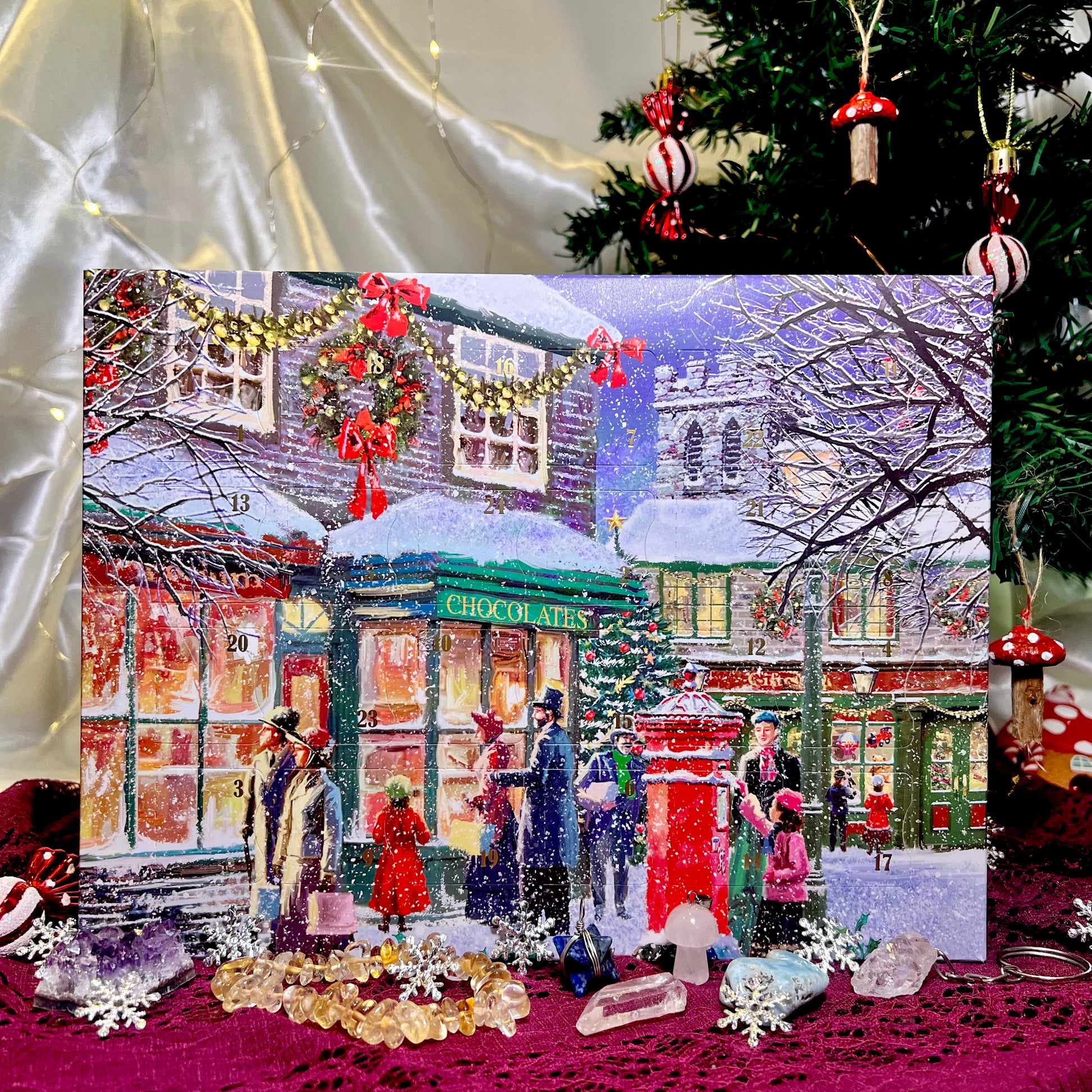 crystal Christmas-themed advent calendar with snowy street scene and people, surrounded by festive decorations and crystals